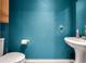 Small half bathroom with teal walls and pedestal sink at 4689 S Swadley Way, Morrison, CO 80465