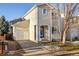 Tan two-story house with a blue front door, small yard, and attached garage at 4689 S Swadley Way, Morrison, CO 80465