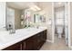 Elegant bathroom with double sinks, a large mirror, and a separate toilet area at 10877 Skydance Dr, Highlands Ranch, CO 80126