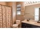 Main bathroom with double sinks, shower/tub combo, and decorative window treatments at 9362 Autumn Ash Ct, Highlands Ranch, CO 80126