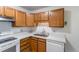 Kitchen with wood cabinets, white appliances, and light countertops at 3144 S Wheeling Way # 209, Aurora, CO 80014