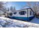 Side view of the house with blue accents and snowy yard at 901 S Osceola St, Denver, CO 80219