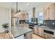 Modern kitchen with light wood cabinets, stainless steel appliances, and a large island at 9066 Harlan St, Westminster, CO 80031