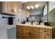 Updated bathroom with wood cabinets and black matte fixtures at 1418 Sunset St, Longmont, CO 80501