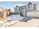 Gray two-story house with a white garage door and snowy front yard at 18971 E Mercer Dr, Aurora, CO 80013