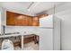 Small galley kitchen with wood cabinets and white appliances at 481 Cragmore St, Denver, CO 80221