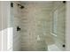 Modern shower with glass enclosure, chevron tile, and built-in seat at 2048 S Holly St # 1, Denver, CO 80222