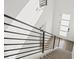 Looking down a modern staircase with metal railing and carpeted steps, leading to an entryway at 2048 S Holly St # 1, Denver, CO 80222