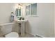 Small bathroom with pedestal sink, toilet and oval mirror at 2290 S Braun Way, Lakewood, CO 80228