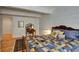 Main bedroom with hardwood floors, queen-sized bed, and dresser with mirror at 6678 S Shawnee Ct, Aurora, CO 80016