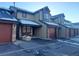 Front view of townhouses with attached garages and a shared parking area at 10812 W Evans Ave # 13, Lakewood, CO 80227