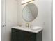 Stylish bathroom featuring a dark green vanity and a large round mirror at 1025 Collyer St, Longmont, CO 80501