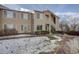 Tan two-story building with snow-covered landscaping at 8457 Thunder Ridge Way # 103, Highlands Ranch, CO 80126