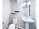 Small bathroom with pedestal sink, toilet, and floating shelves at 1983 S Poplar Ct, Denver, CO 80224