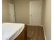 Simple bedroom with double bed, light walls, and wood-look floors at 1266 S Ammons St, Lakewood, CO 80232
