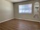 Simple bedroom with wood-look floors and a window with blinds at 1266 S Ammons St, Lakewood, CO 80232