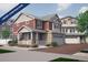 Two-story home with red siding, stone accents, and a two-car garage at 1224 Sugarloaf Ln, Erie, CO 80516