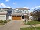 Two-story house with gray siding, brown garage door, and landscaped yard at 5555 Perth Ct, Denver, CO 80249