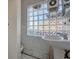 Small bathroom with pedestal sink, toilet, and a glass block window at 3333 Colorado Blvd, Denver, CO 80205