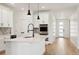 Modern white kitchen with island, stainless steel appliances, and herringbone backsplash at 42962 Colonial Trl, Elizabeth, CO 80107