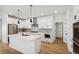 Modern white kitchen with island, stainless steel appliances, and herringbone backsplash at 42962 Colonial Trl, Elizabeth, CO 80107
