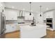 Modern white kitchen with island, stainless steel appliances, and herringbone backsplash at 42962 Colonial Trl, Elizabeth, CO 80107