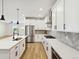 Modern white kitchen with island, stainless steel appliances, and herringbone backsplash at 42962 Colonial Trl, Elizabeth, CO 80107