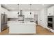 Modern white kitchen with island, stainless steel appliances, and herringbone backsplash at 42962 Colonial Trl, Elizabeth, CO 80107