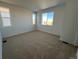 Spacious bedroom with neutral wall and carpeting and two windows at 22861 E Stanford Ln # A, Aurora, CO 80015