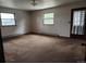 Simple carpeted bedroom with two windows and door at 8025 S Cody St, Littleton, CO 80128