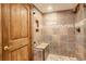 Shower with stone tile, built-in seat, and glass enclosure at 5237 Bear Mountain Dr, Evergreen, CO 80439