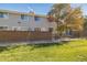 Gray siding townhouse exterior with brick wall and small fenced yard at 1745 W 102Nd Ave, Thornton, CO 80260
