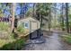 Small storage shed nestled in the woods with a trail nearby at 1065 Independence Dr, Larkspur, CO 80118
