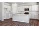 Bright kitchen with white cabinets, island, stainless steel appliances, and wood-style flooring at 3453 N Irvington St, Aurora, CO 80019