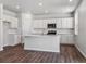 Modern kitchen with white shaker cabinets, island, and stainless steel appliances at 3453 N Irvington St, Aurora, CO 80019