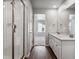 Main bathroom with dual vanities, a glass-enclosed shower, and modern fixtures at 3453 N Irvington St, Aurora, CO 80019