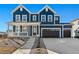 Two-story farmhouse-style home with a charming front porch and a three-car garage at 959 Eldorado Ln, Louisville, CO 80027