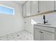 Laundry room with a sink, cabinets, and patterned floor at 959 Eldorado Ln, Louisville, CO 80027