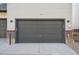 Attached garage with a dark gray door and exterior lighting at 461 Interlocken Blvd # 105, Broomfield, CO 80021