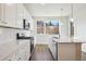 Modern kitchen with white cabinets, quartz countertops, and stainless steel appliances at 461 Interlocken Blvd # 105, Broomfield, CO 80021