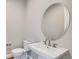 Powder room with pedestal sink and large round mirror at 574 Agoseris Way, Castle Rock, CO 80104