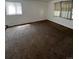 Spacious living room with brown carpeting and large windows at 14190 E Gunnison Pl, Aurora, CO 80012