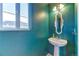 Small bathroom with pedestal sink, decorative mirror, and teal walls at 20378 E Dartmouth Dr, Aurora, CO 80013