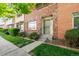 Brick townhome exterior with a manicured lawn and walkway at 9079 E Nassau Ave, Denver, CO 80237