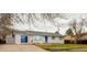 Exterior view of a single-story home featuring a white brick facade, blue door, and attached garage at 234 Lansing St, Aurora, CO 80010