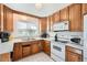 Kitchen with wood cabinets and white appliances at 10762 Blue Jay Ln, Northglenn, CO 80233