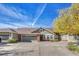 Front view of townhome with two-car garage and mature tree at 8201 S Winnipeg Ct, Aurora, CO 80016