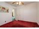 Bedroom with red carpet, ceiling fan, and access to another room at 4020 Newman St, Wheat Ridge, CO 80033