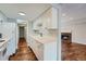View of kitchen with white cabinets, hardwood floors, and a fireplace in the adjacent living room at 6420 S Dayton St # J06, Englewood, CO 80111