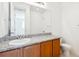 Bathroom with wood cabinets and granite countertop at 9674 Truckee St, Commerce City, CO 80022